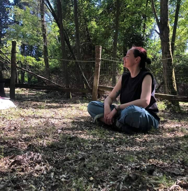 foto stefania, autrice del sito, in un bosco che guarda le fronde degli alberi
